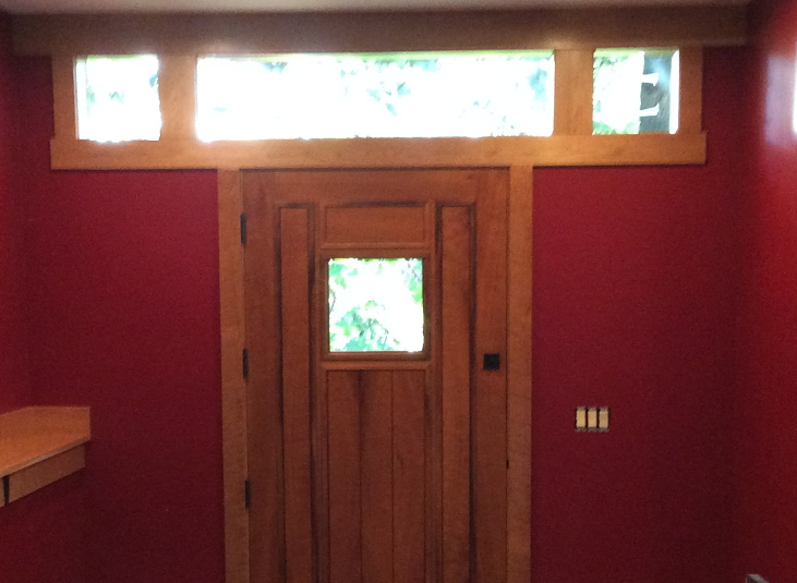 Front entry detail of the Caldwell house showing the door, wood siding, and clean modern architecture of the residence.